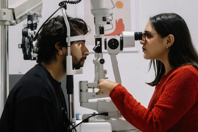 Optometrist examining a patient at the slit lamp