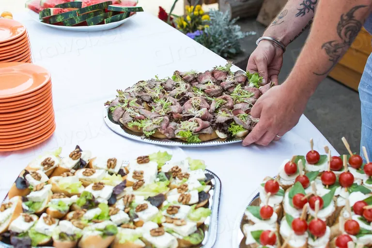 Caterer laying out platters of canapés